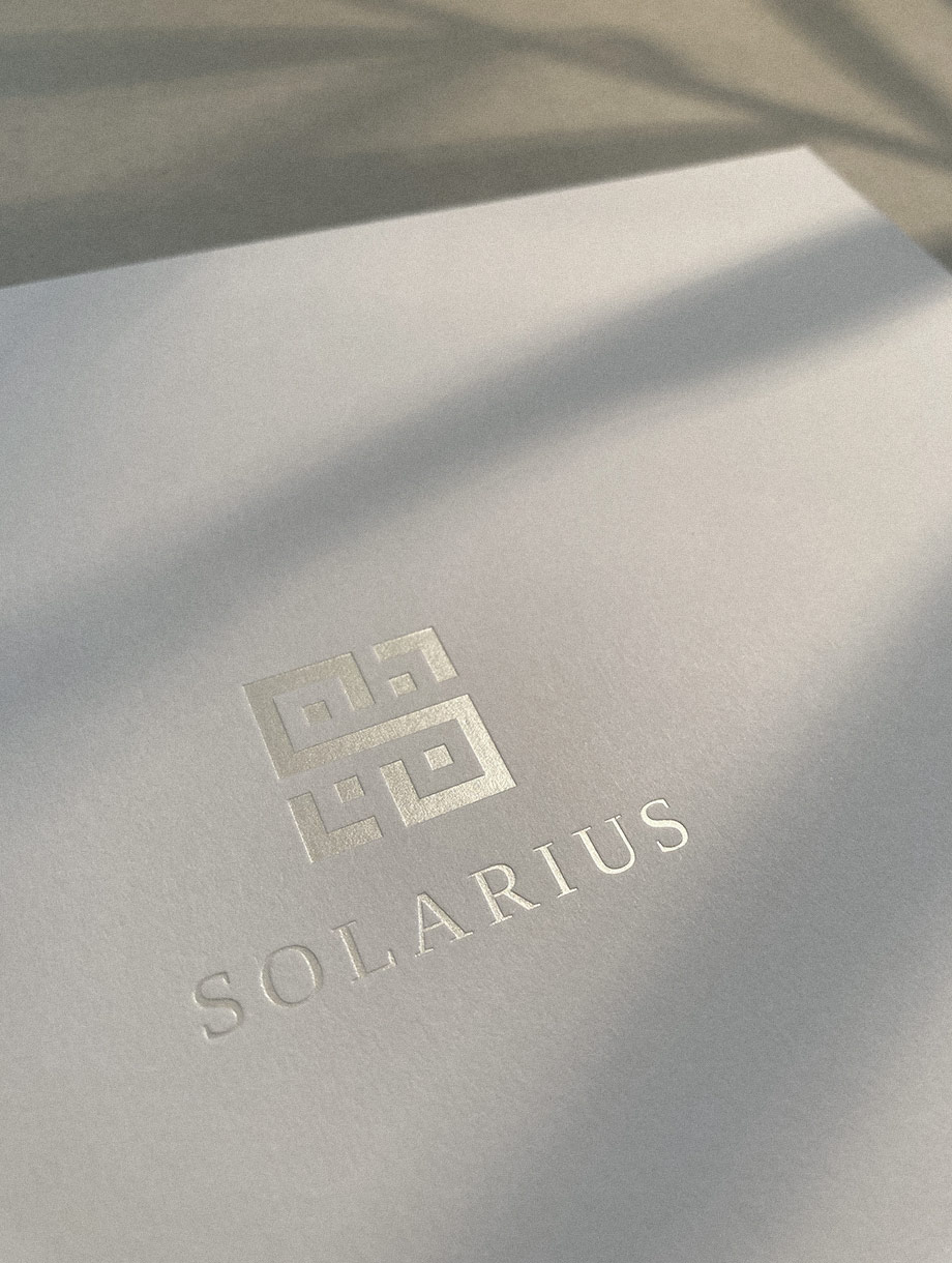 immobilienbroschüre mit geprägtem solarius logo mit silber folie auf weissem papier
